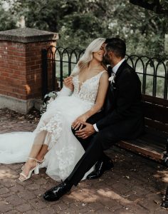 Renee and Vik wedding - Joy By Joelle Bride and groom sitting outside on a park bench - wedding styled by Joy By Joelle.